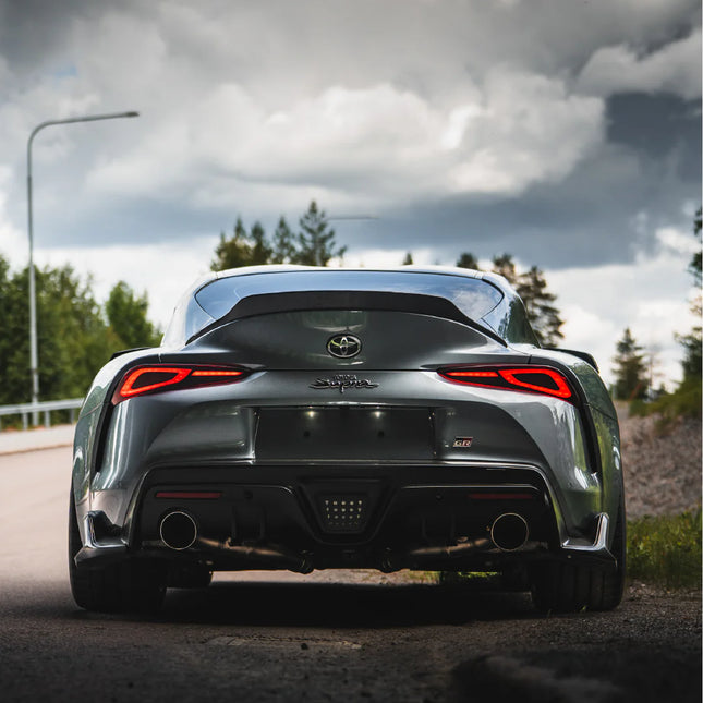 Harmaa Toyota Supra auton takaosa ilman rekisterikilpeä. Magneettinen rekisterikilven pidike korostaa siistiä ja sporttista ulkonäköä.