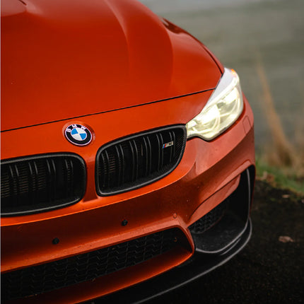 Oranssi BMW M3 auton keula ilman rekisterikilpeä. Magneettinen rekisterikilven teline korostaa tyylikästä ulkonäköä.